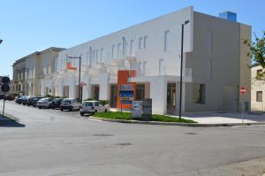un edificio con coches aparcados al lado de una calle en Vecchia Fabbrica Apartments, en Castrignano deʼ Greci