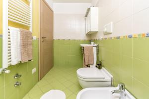 ein grünes Bad mit einem WC und einem Waschbecken in der Unterkunft Alessia's Flat- Portello 3 in Mailand