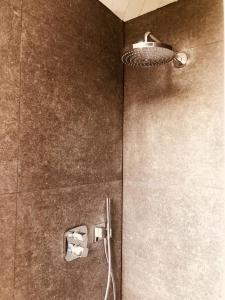 a bathroom with a shower with a light on the wall at Mar y Luz in Koksijde