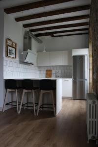 cocina con mesa y nevera en Eguzkilorea en Hondarribia