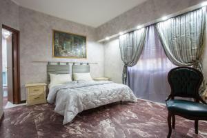 a bedroom with a bed and a chair and a window at Casa Romana in Tor Vergata