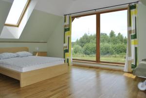 a bedroom with a bed and a large window at Vilks un Briedis Holiday Home & Wellness Area in Smiltene