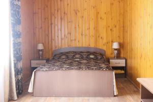 ジヴェエヴォにあるPlaneta Guest Houseのベッドルーム1室(木製の壁のベッド1台、テーブル2台付)