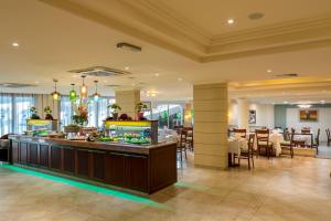 a restaurant with a buffet in the middle of a room at Aquamare Beach Hotel & Spa in Paphos