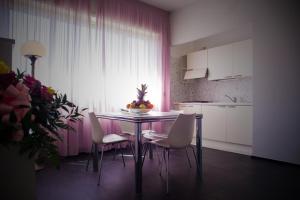 uma cozinha com uma mesa e cadeiras com uma tigela de fruta em Residence Hotel Torino Uno em Turim