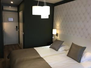 a bedroom with a white bed with two pillows at Het Wapen van Elst in Elst