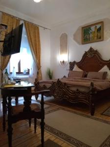 Schlafzimmer mit einem Bett, einem Schreibtisch und einem TV in der Unterkunft Villa Imperia, Museums-Hotel in Blankenburg