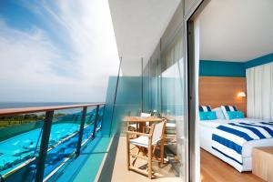 een slaapkamer met een bed en een balkon met een zwembad bij Falkensteiner Hotel & Spa Iadera in Zadar