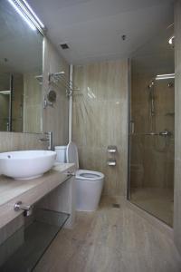 un bagno con lavandino, doccia e WC di IW Hotel a Hong Kong