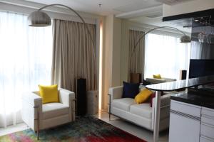 un soggiorno con 2 sedie bianche e un tavolo di IW Hotel a Hong Kong
