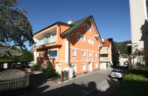 シュラートミンクにあるAppartements Schwaiger by Schladming-Appartementsの通り側の大きなオレンジ色の建物