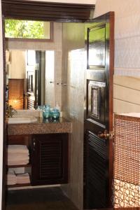 a bathroom with a sink and a mirror at Sibaja Palms Sunset Beach Luxury Apartments in Taling Ngam Beach