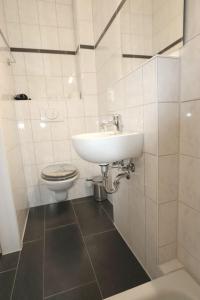 a white bathroom with a sink and a toilet at Penny Pension in Wolfsburg