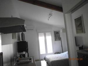 Un dormitorio pequeño con una cama y una ventana. en Studio équipé avec jardin+parking à la plage..., en La Ciotat