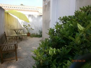 un patio con panca, tavolo e alcune piante di Studio équipé avec jardin+parking à la plage... a La Ciotat