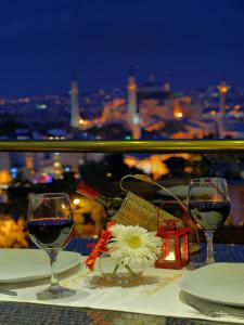 a table with a glass of wine and a cake on it at Burckin Hotel in Istanbul
