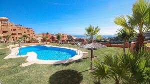 a swimming pool in a yard with palm trees at Coto Real Andros 201 in Manilva