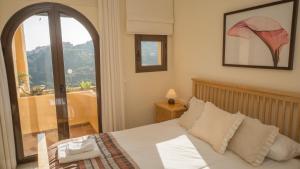 a bedroom with a bed and a large window at Coto Real Naxos 321 in Manilva