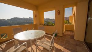 a table and chairs in a room with windows at Coto Real Naxos 321 in Manilva