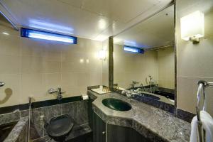 a bathroom with a sink and a mirror at Ramee Guestline Hotel Khar in Mumbai