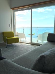 セジンブラにあるT2 com vista marのベッドルーム1室(海の景色を望む大きな窓付)