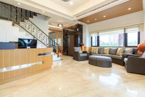 a living room with couches and a tv at Urban Oasis Inn in Luodong