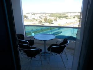a table and chairs in a room with a large window at Le luxe du Lac 2 in Berges Du Lac