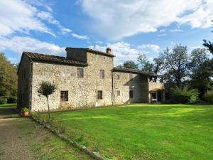 an old stone building with a grass yard at Authentic farm holiday with swimming pool pizza oven spacious garden and private terrace in Pietraviva