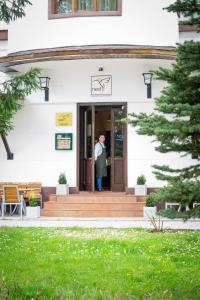 a man standing at the door of a white building at Nest in Drobeta-Turnu Severin