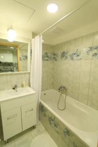 a bathroom with a tub and a sink and a bath tub at Velence Spa Lake Apartman in Velence