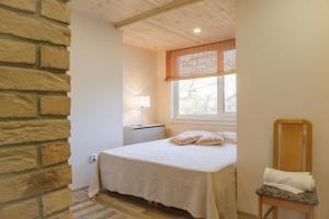 ein Schlafzimmer mit einem Bett und einer Ziegelwand in der Unterkunft Kaevu Holiday House in Pärnu