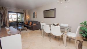 een woonkamer met een tafel en witte stoelen bij Marina del Castillo 214 in Manilva