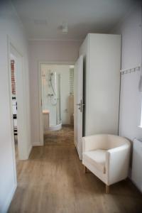シュチェチンにあるAramia Apartamentyの白い椅子とバスルームが備わる白い部屋です。