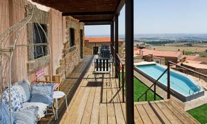 a balcony with a view of a house with a swimming pool at Casa da Cisterna in Castelo Rodrigo