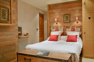 sypialnia z dużym białym łóżkiem z czerwonymi poduszkami w obiekcie Hotel-Spa Le Morillon Charme & Caractère w mieście Morillon