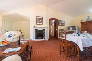 een woonkamer met een tafel en een open haard bij Villa Corrasi Oliena Luxury in Oliena