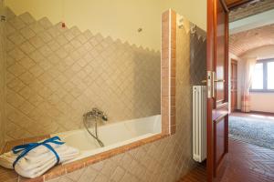 Villa Corrasi Oliena Luxury في أوليينا: حوض استحمام مع صنبور في الحمام