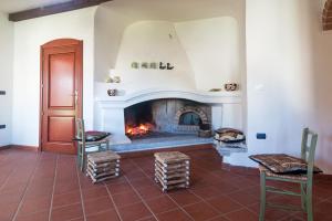 een woonkamer met een open haard en 2 stoelen bij Villa Corrasi Oliena Luxury in Oliena