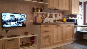 a kitchen with a tv hanging on a wall at Casetta next to the Creek Dino Buzzati in Belluno