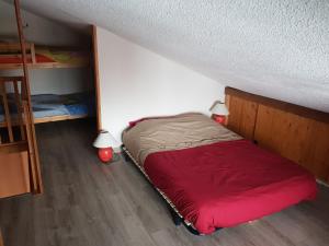 イゾラ 2000にあるLes Adrets 1 Isola 2000の小さなベッドルーム(赤いベッド1台、ランプ2つ付)
