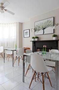 a dining room with white chairs and a table and a fireplace at 2 Crescent Gardens Guest House in Bath