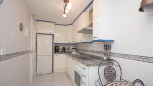 マニルバにあるMarina Real 415の白いキャビネットと青のアクセントが特徴のキッチン