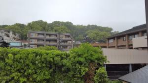 vistas a una ciudad con edificios y árboles en Pension Baden Heim en Nagasaki