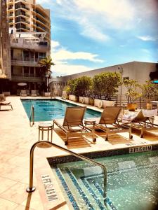 una piscina con tumbonas junto a un edificio en Apartment at De Soleil Hotel on Ocean Drive, en Miami Beach
