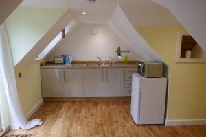 a kitchen with a sink and a refrigerator at The Den , Sengera in Inverness
