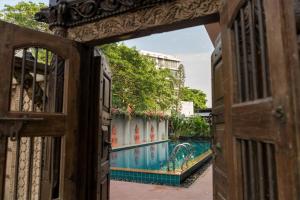 un portail ouvert avec une piscine en arrière-plan dans l'établissement Thanyawintra Boutique and Spa, à Chiang Mai