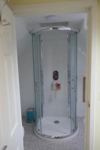 a shower with a glass door in a bathroom at The Den , Sengera in Inverness