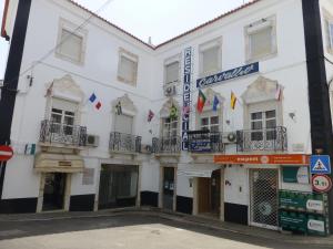 ein weißes Gebäude mit Flaggen auf den Balkonen in der Unterkunft Residencial Carvalho in Estremoz