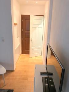a room with a door and a table with a remote control at Gästeapartment Leipzig City in Leipzig