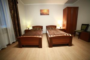 two beds in a room with a wooden floor at Hotel Kruiz in Krasnodar